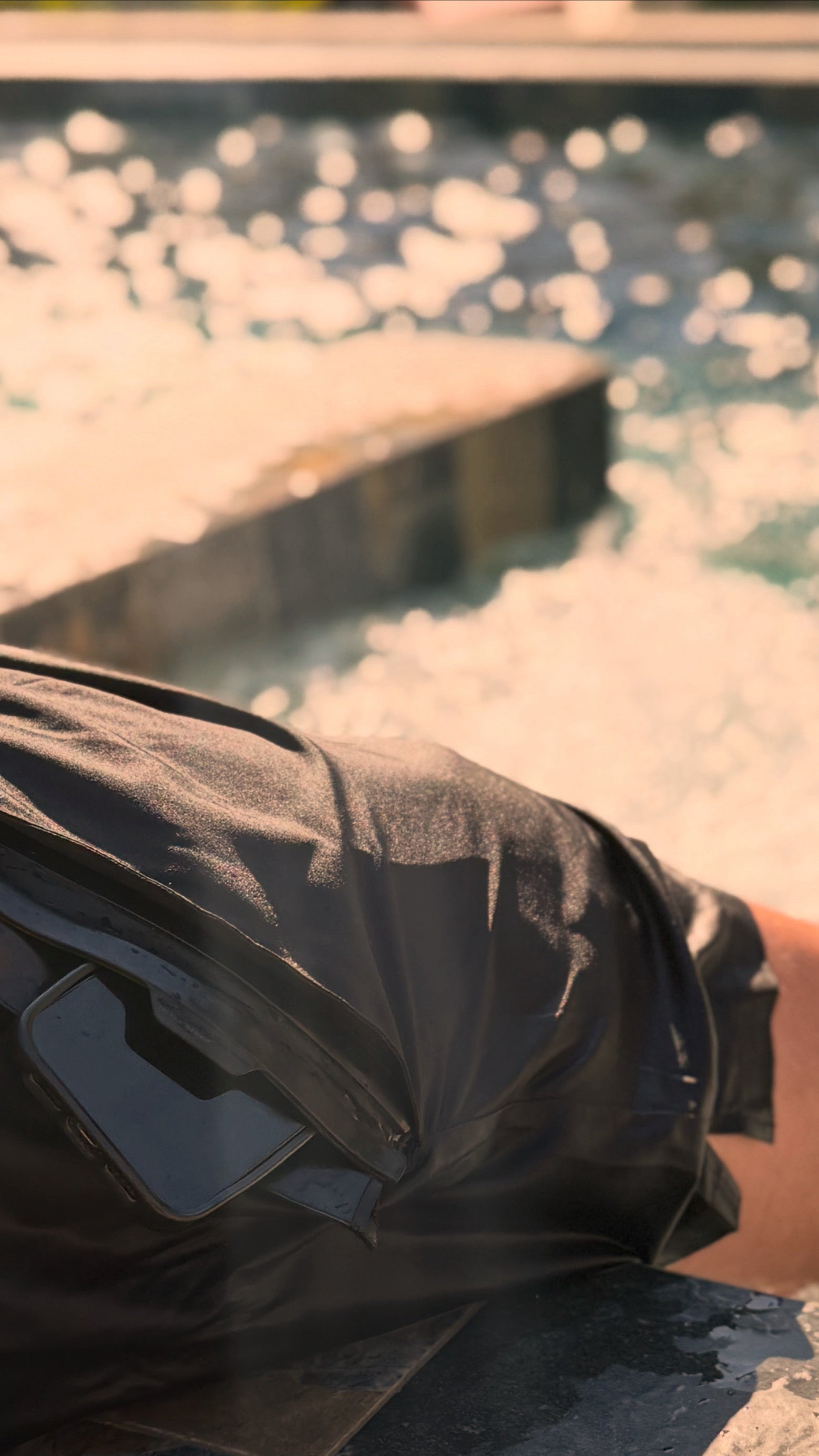 black secure swim shorts with a waterproof pocket protecting a smart phone from water at a pool 