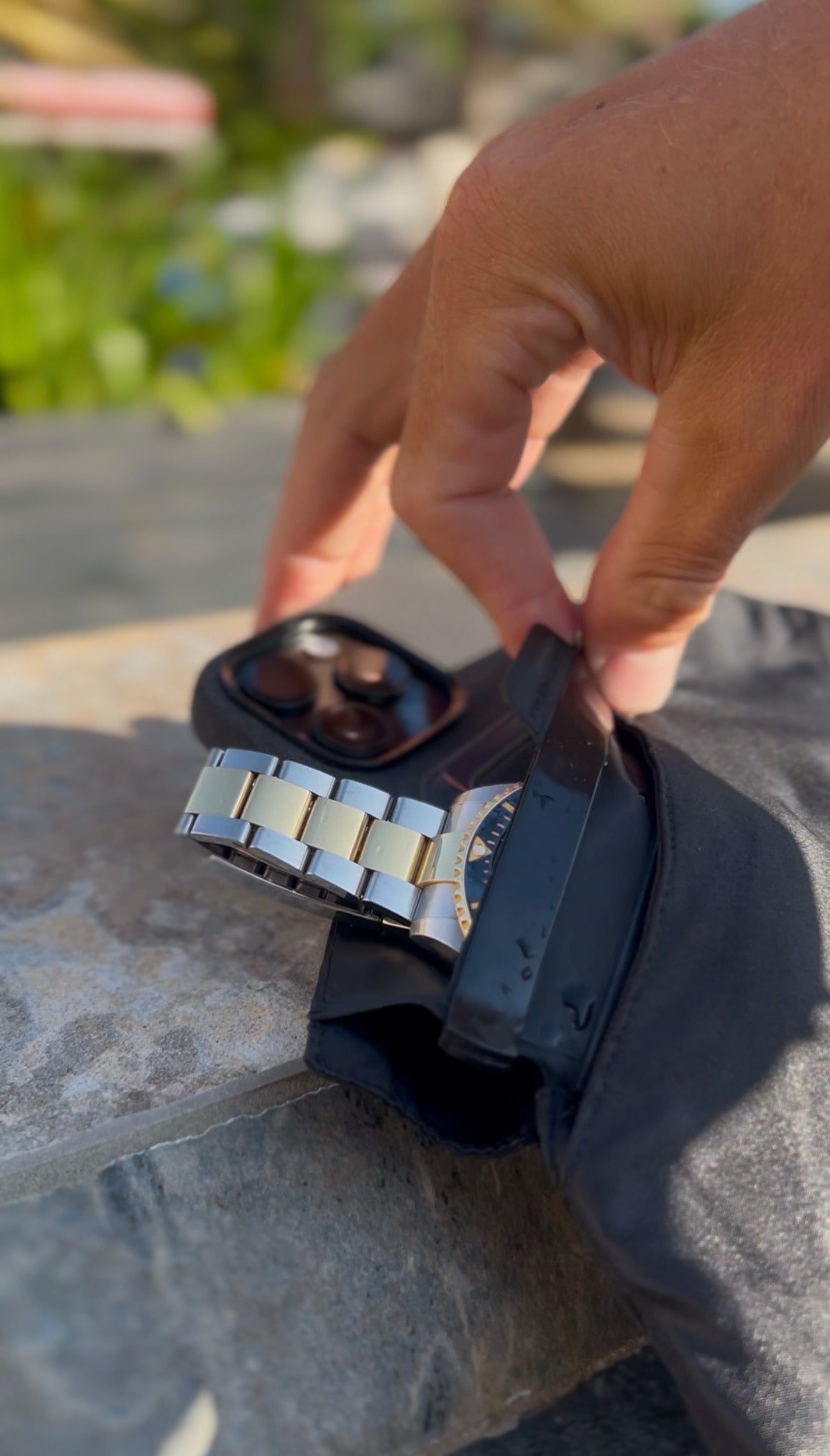 close-up of the secure swimwear snapshut waterproof pocket protecting a smart phone and watch inside black waterproof swim shorts